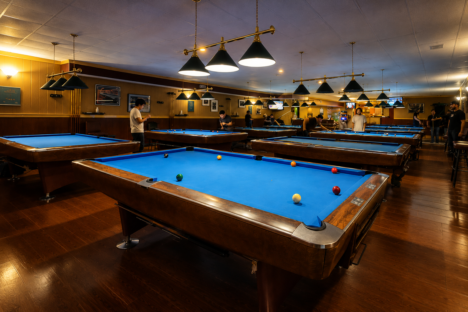 Main billiards room with polished pool tables and pendant lighting